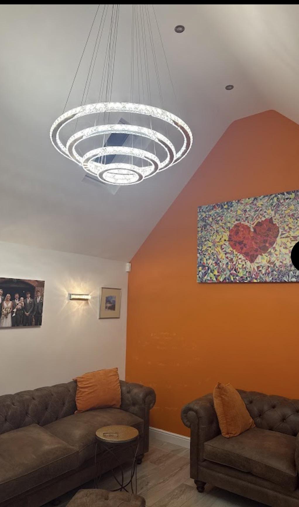 Freshly redecorated living room with statement lighting and a bold feature wall — interior decorating by MNC Construction, Billericay, Essex