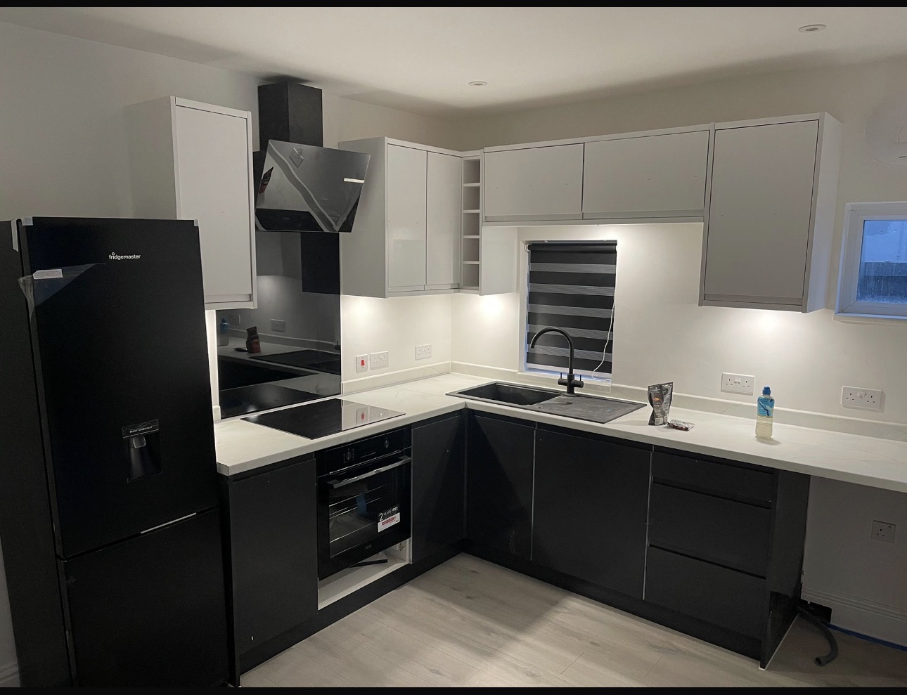 Modern kitchen with newly fitted dark grey and white units — kitchen fitting by MNC Construction, Billericay, Essex