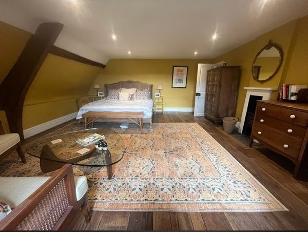 Elegant period bedroom with feature fireplace and exposed beams, freshly decorated — interior decorating by MNC Construction, Essex